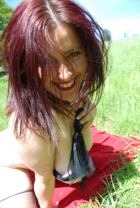 Middle-aged UK woman Juicey Janey unveils her big tits and bush in a field 27435247